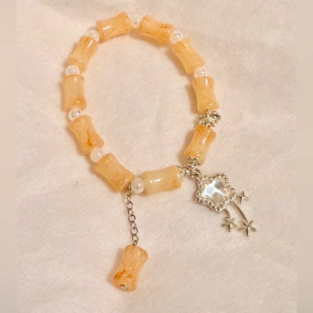 Beaded bracelet, NIB, marbling peach w pearls and a shooting star charm.